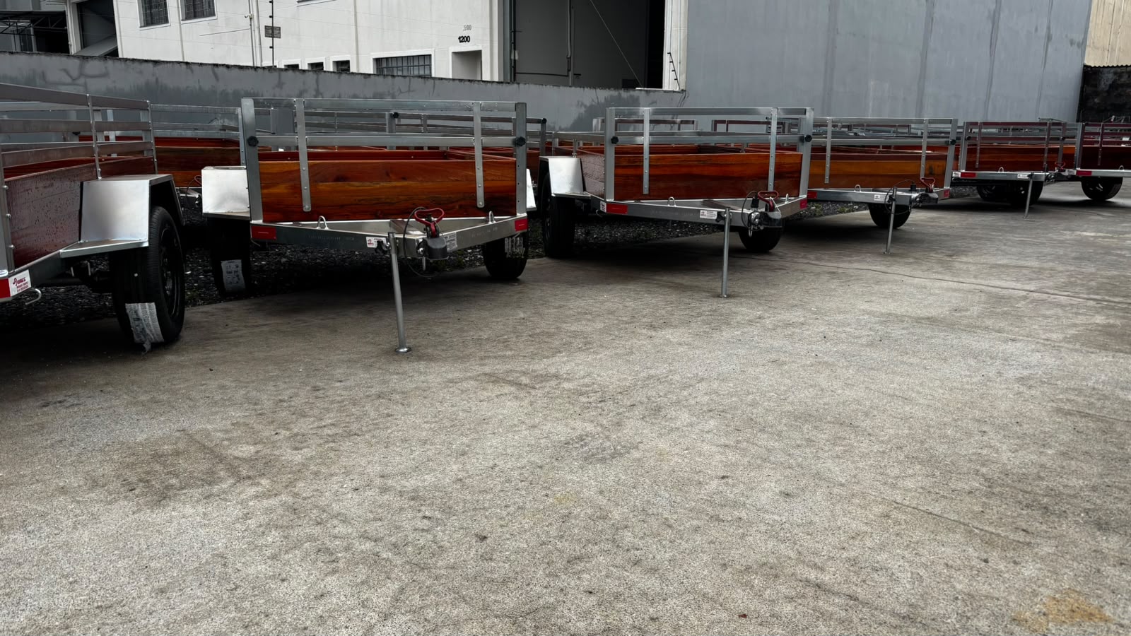 Carretinhas Daeg alinhadas no pátio, com estrutura metálica e laterais de madeira